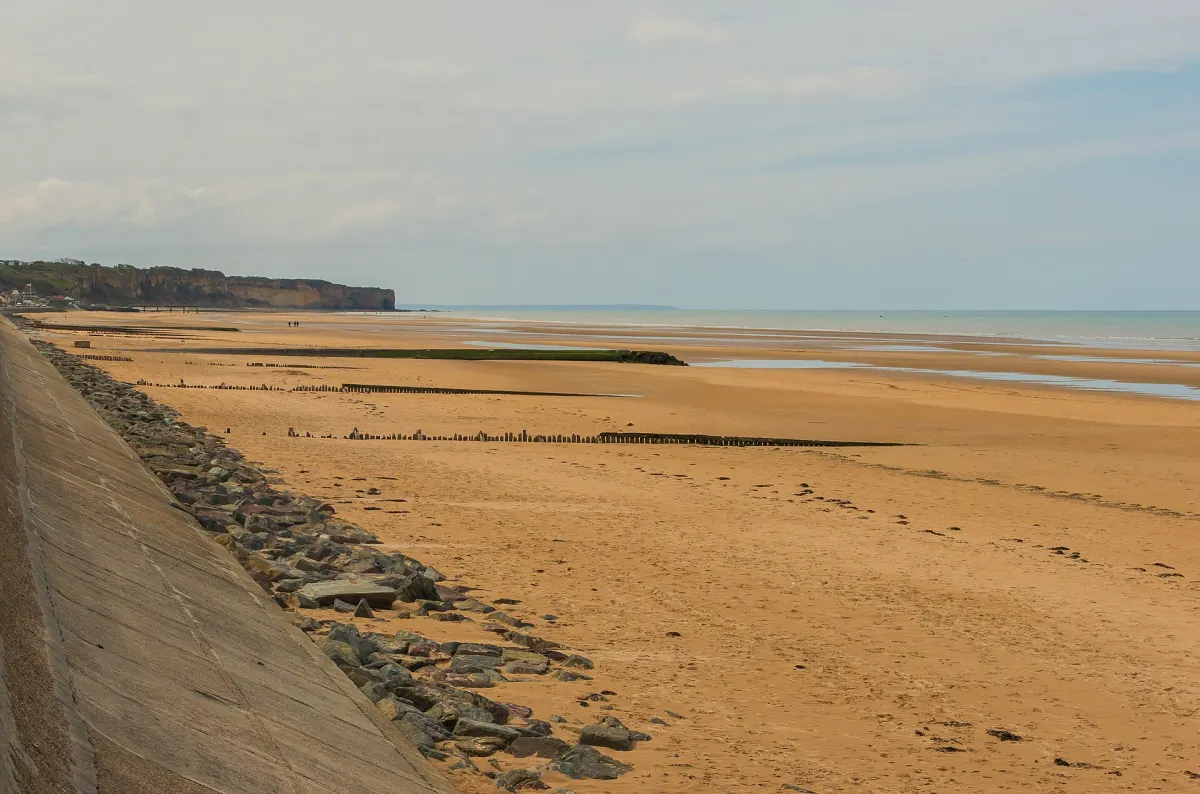 Omaha Beach at low tide with a sea wall and a long stretch of sand